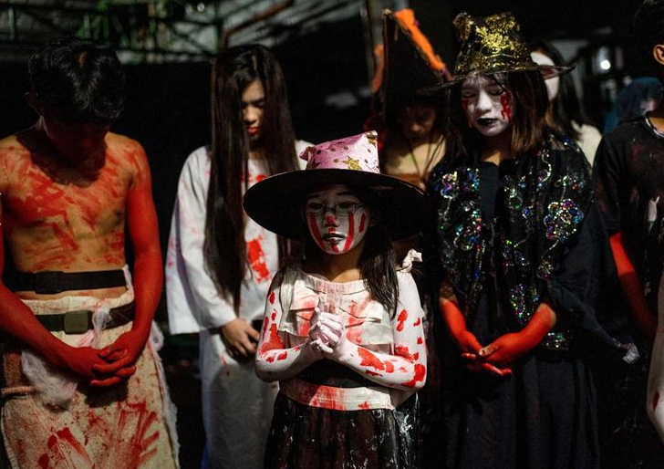أطفال يرتدون أزياء الهالوين يصلون قبل أن يفتحوا منزل الرعب في مانيلا بالفلبين ، 31 أكتوبر 2022. رويترز  ليزا ماري ديفيد