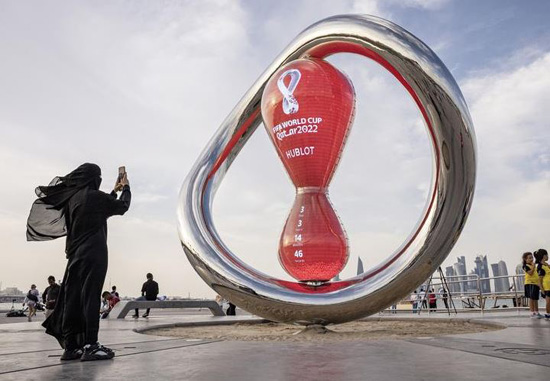 أحد المعجبين يلتقط صورة لساعة العد التنازلي لبدء كأس العالم في الدوحة