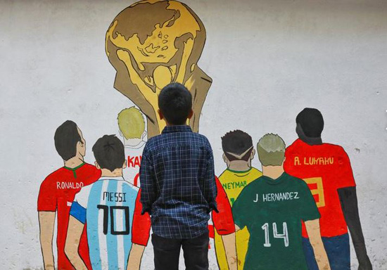 صبي ينظر إلى لوحة جدارية قبل انطلاق مونديال قطر 2022