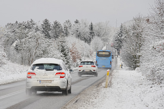 يقود سائقو السيارات على طريق مغطى بالثلوج
