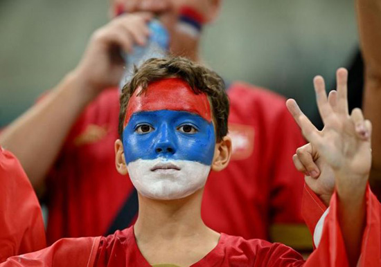 مشجع صربيا يرتدي طلاء على الوجه داخل الملعب قبل المباراة ضد البرازيل