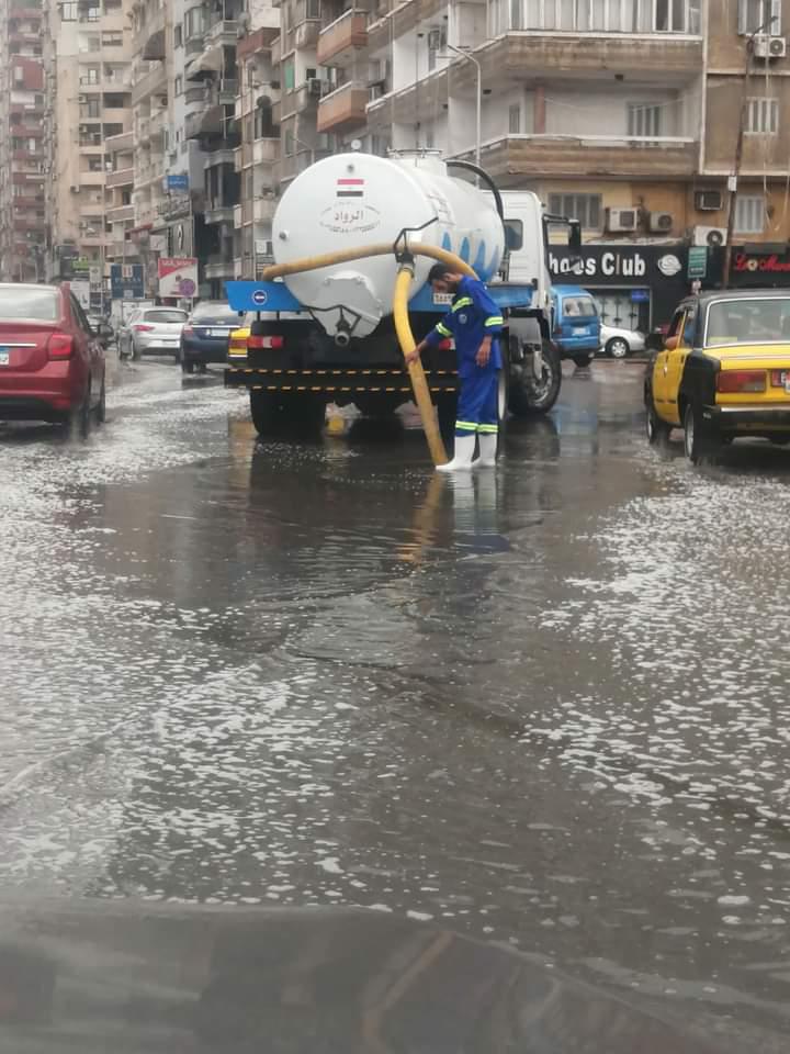 عمال الصرف أثناء سحب تراكمات لمياة الأمطار