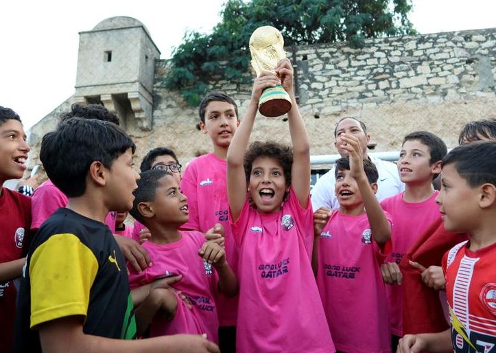 أطفال يحتفلون بفوزهم في المباراة النهائية لكرة القدم كأس العالم في منطقتنا ، وهي مسابقة رمزية نظمتها منظمة محلية حومة الرياضة ، قبل كأس العالم لكرة القدم 2022 ، في تونس ،