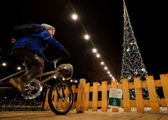 طفل يركب دراجة لتشغيل تركيبات أضواء عيد الميلاد في ساحة مقاطعة بودابست لتوفير التكاليف باستخدام الأضواء المستدامة (2)