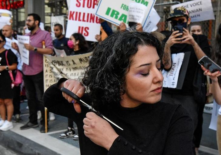 امرأة تقص شعرها خلال احتجاج ضد النظام الإسلامي في إيران ووفاة مهسا أميني في مدينة نيويورك