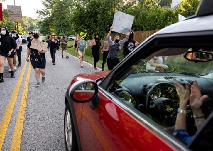 امرأة تصفق في سيارتها بينما كان نشطاء حقوق الإجهاض يسيرون في مسيرة إلى منزل قاضي المحكمة العليا الأمريكية صمويل أليتو في الإسكندرية ، فيرجينيا ،