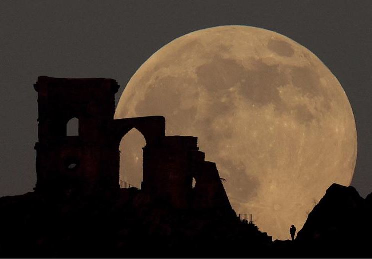 القمر الذئب يرتفع فوق جزيرة ماو كوب فولي ، بريطانيا