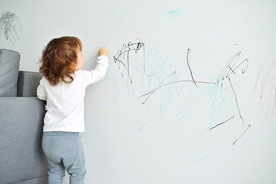 طفل يرسم على الحائط