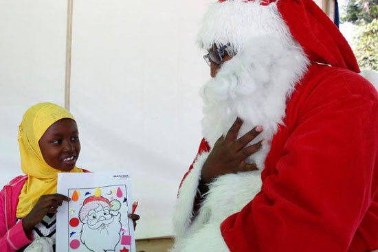 طفل مسلم يعرض صورة بابا نويل لفيكتور نجوروج