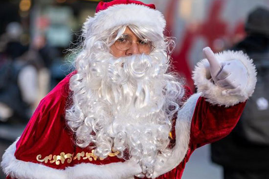 شخص يرتدي زي بابا نويل يقف لالتقاط الصور في تايمز سكوير في مدينة نيويورك