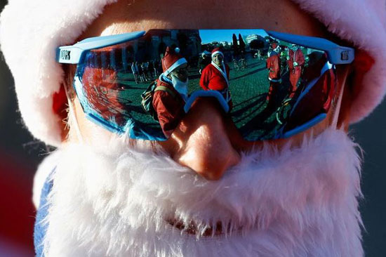 يظهر الأشخاص الذين يرتدون أزياء عيد الميلاد في النظارات الشمسية في يوم الرحلة عبر وسط المدينة لجمع الأموال لجمعيات الأطفال الخيرية في روما