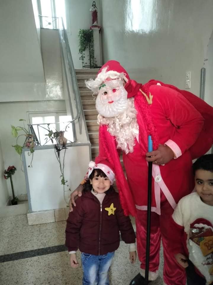 أطفال المدارس وفرحتهم بشخصية بابا نويل بإسنا