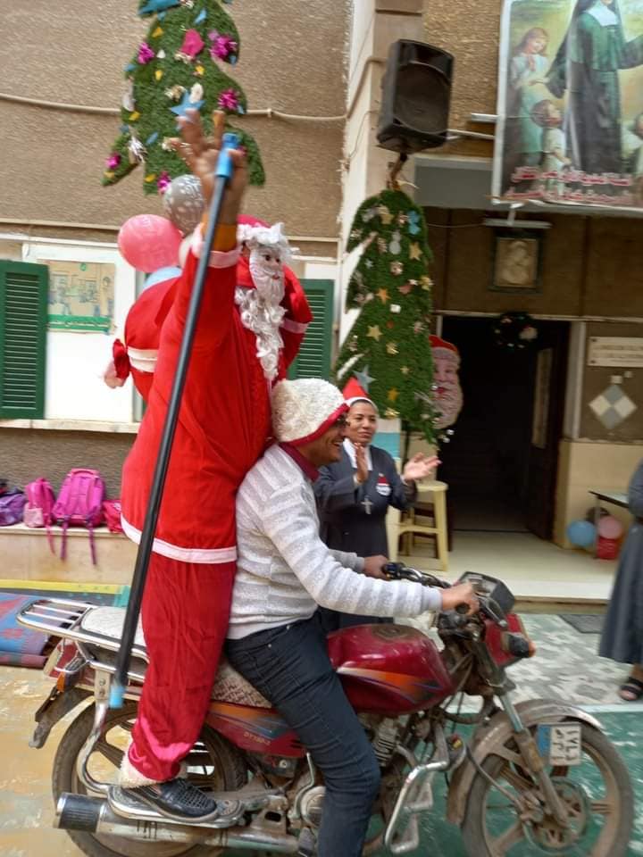 بابا نويل يجوب شوارع إسنا على دراجة بخارية