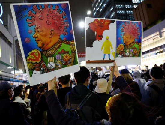 امرأة من هونغ كونغ تحمل لافتة تصور الرئيس الصيني شي جين بينغ في طوكيو