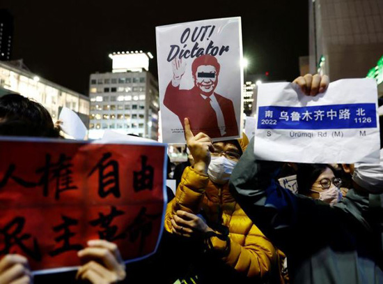رجل صيني يعيش في اليابان يحمل لافتة في احتجاج تضامني ضد عمليات الإغلاق