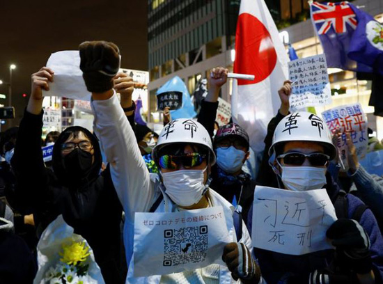 متظاهرون يحملون لافتات خلال احتجاج تضامني في طوكيو