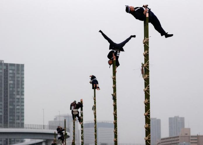 يعرضون مهاراتهم في التوازن على سلالم من الخيزران خلال عرض عام جديد نظمته فرقة الإطفاء في طوكيو ، اليابان