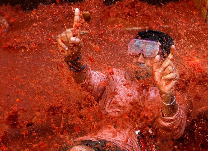 أحد المحتفلين يلعب في لب الطماطم خلال مهرجان لا توماتينا السنوي لمكافحة الطعام في بونول بإسبانيا