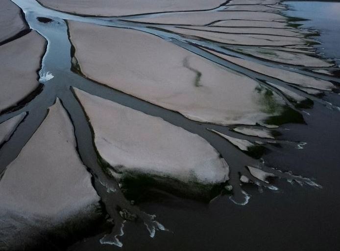 منظر جوي يظهر مجرى رافد يمر عبر المسطحات الجافة لبحيرة بويانغ