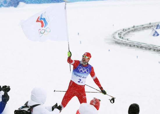سيرجي أوستيوغوف من اللجنة الأولمبية الروسية يحتفل بالميدالية الذهبية في تتابع التزلج الريفي