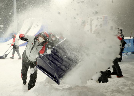 يقوم العمال بإزالة الثلوج في المكان حيث يتم تأجيل الحدث بسبب تساقط الثلوج بكثافة في هوائيات التزلج
