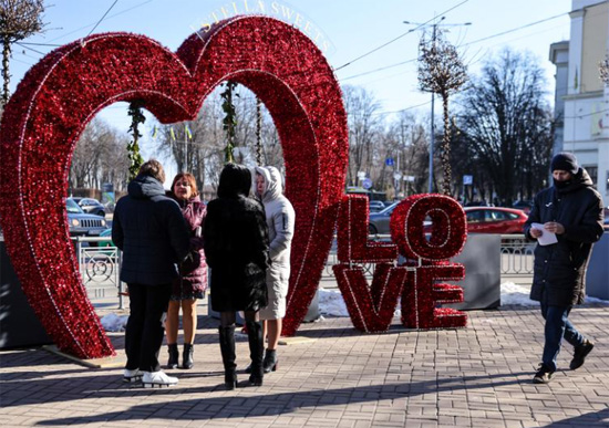 نساء يتحدثن بجانب زخرفة على شكل قلب خلال عيد الحب في أوكرانيا