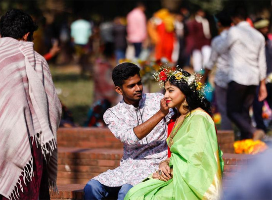 رجل يثبت إكليلا من الزهور على رأس فتاة في يوم عيد الحب في دكا بنجلاديش