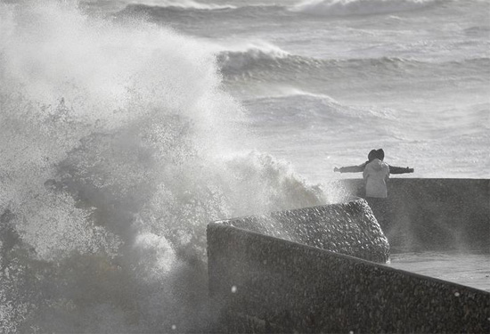 الناس يشاهدون الأمواج تتكسر خلال العاصفة يونيس في برايتون  بريطانيا