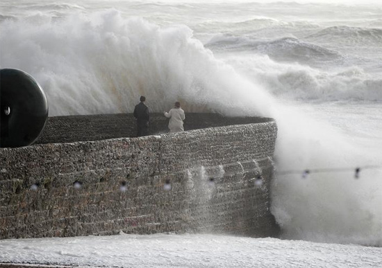 الناس يشاهدون الأمواج تتكسر خلال العاصفة يونيس