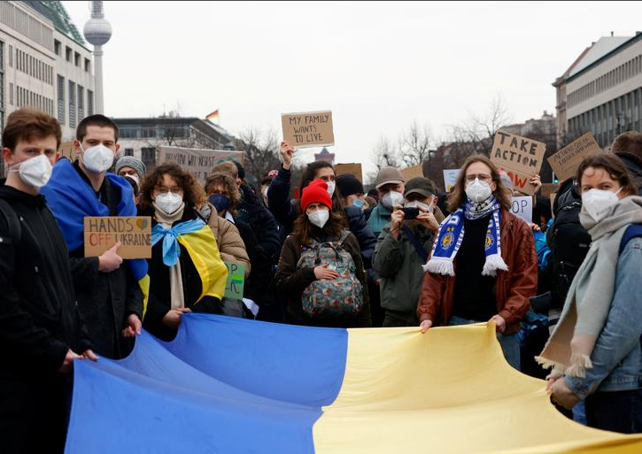 متظاهرون يحملون العلم الأوكراني خلال مظاهرة مناهضة للحرب في بوابة براندنبورغ في برلين