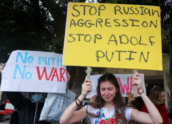 لبنانيون وأوكرانيون يعيشون في لبنان يحملون لافتات خلال احتجاج على الغزو الروسي