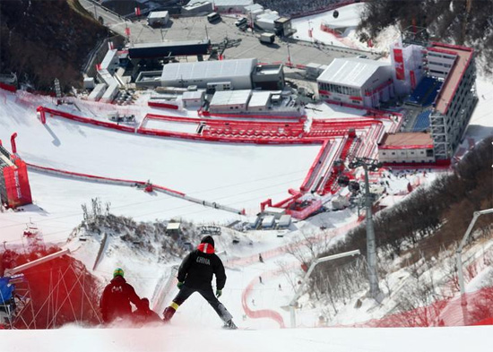 يقوم الطاقم الأولمبي بفحص المسار على المنحدر قبل التزلج على المنحدرات في جبال الألب للرجال
