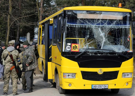 جنود يقفون بجوار حافلة تحطم زجاجها  الامامي
