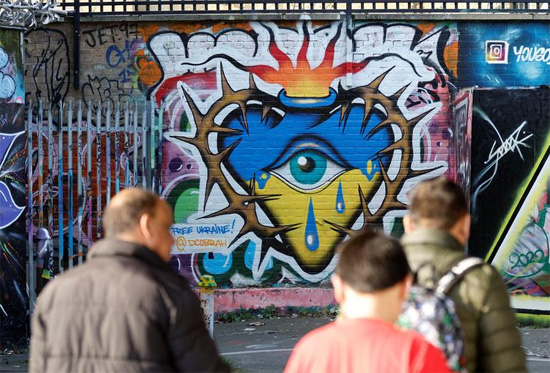 أشخاص يمشون بالقرب من الأعمال الفنية لدعم أوكرانيا