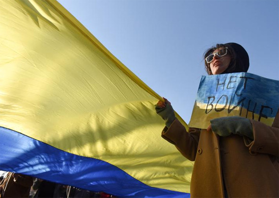 متظاهر يحمل علمًا أوكرانيًا فى صيربيا