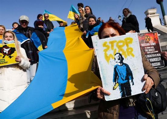 مواطنون أوكرانيون يرفعون الأعلام واللافتات خلال مظاهرة ضد الغزو الروسي لأوكرانيا  فى اليونان