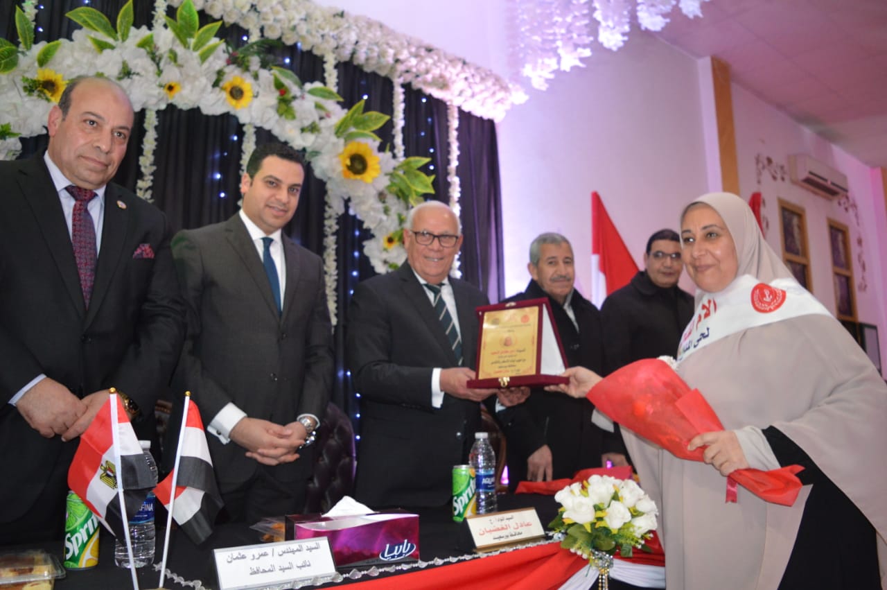 محافظ بورسعيد يهدى درع التكريم لاحد الامهات
