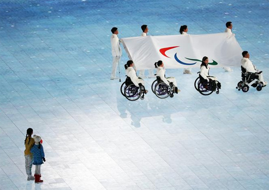 رياضيون سابقون يحملون علم أولمبياد المعاقين خلال حفل الافتتاح