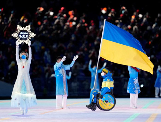 حامل العلم ماكسيم ياروفي من أوكرانيا خلال استعراض الرياضيين
