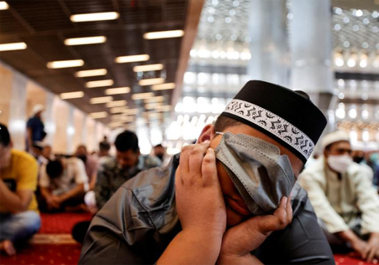 صبي مسلم يغطي وجهه بقناع وقائي فى مسجد بجاكارتا
