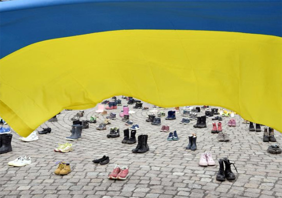 يتم وضع الأحذية والأحذية والشموع خلال مظاهرة نظمتها الجمعية الأوكرانية في فنلندا لإحياء ذكرى الأطفال الذين قتلوا أثناء الغزو الروسي