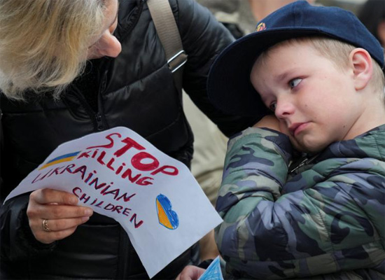 طفل يتفاعل عندما يشارك أشخاص في مظاهرة مناهضة لروسيا خارج السفارة الروسية في وارسو بولندا