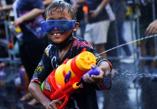 صبي يلعب بالماء أثناء احتفاله خلال عطلة سونغكران التي تصادف العام التايلاندي الجديد في بانكوك
