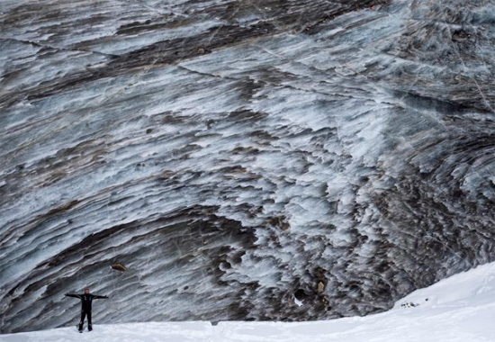 سائح يقف لالتقاط صورة على نهر بوغدانوفيتش الجليدي