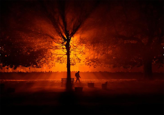 رجل يستخدم شعلة للسير في حديقة أثناء الضباب البارد ليلاً في أثبوي أيرلندا