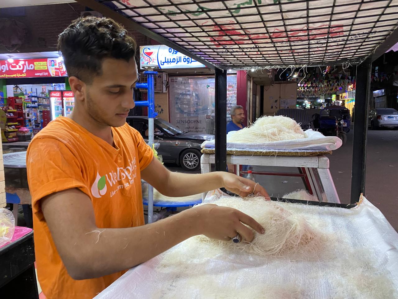 محمد يضع كميات الكنافة قبل بيعها
