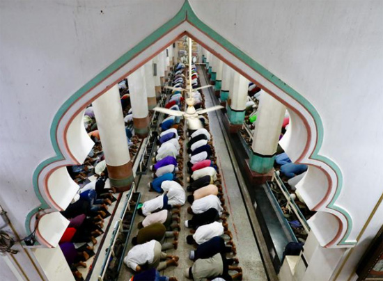 أشخاص يؤدون صلاة في مسجد خلال أول أيام شهر رمضان المبارك ، في دكا ببنغلاديش