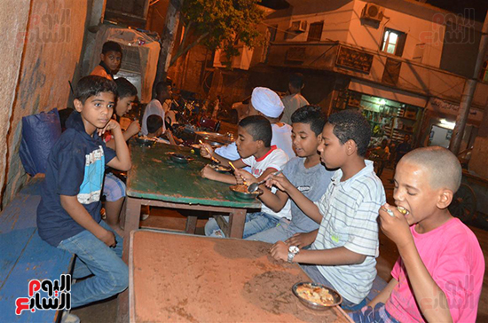 أبناء قرى الأقصر يستمتعون بأكل الفول النابت أمام المساجد بعد التراويح