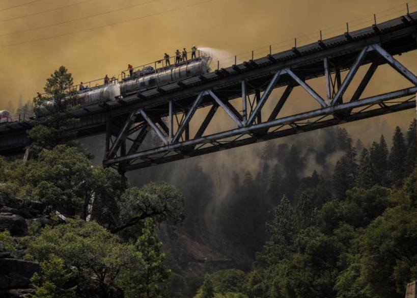 رجال الإطفاء يرشون الماء من قطار إطفاء مصمم لمكافحة حرائق الغابات على النقاط الساخنة فى كاليفورنيا