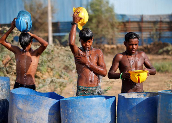 عمال يسكوبون الماء على جسدهم